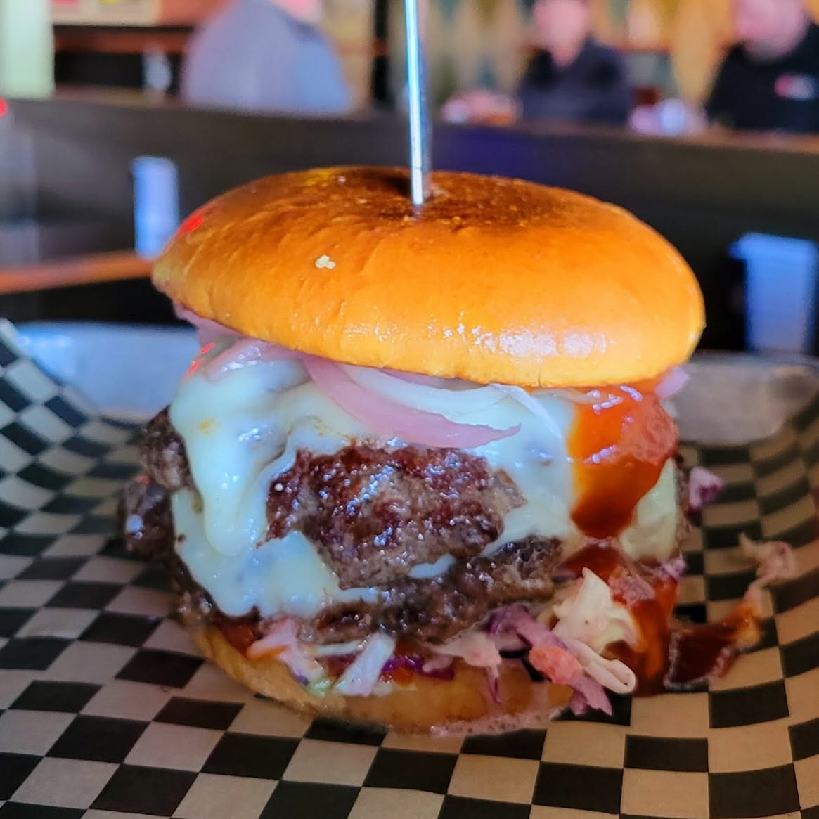 Valley double cheeseburger with onion rings on checkered paper